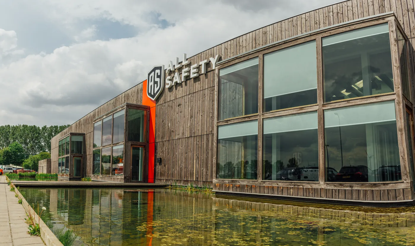 The wooden All Safety building in Terneuzen, reflected in the water.
