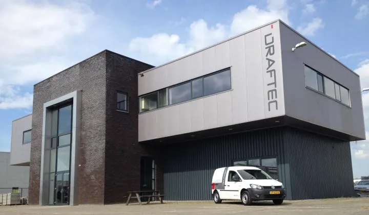 Het bedrijfspand van Draftec met een bedrijfsbus voor de deur.