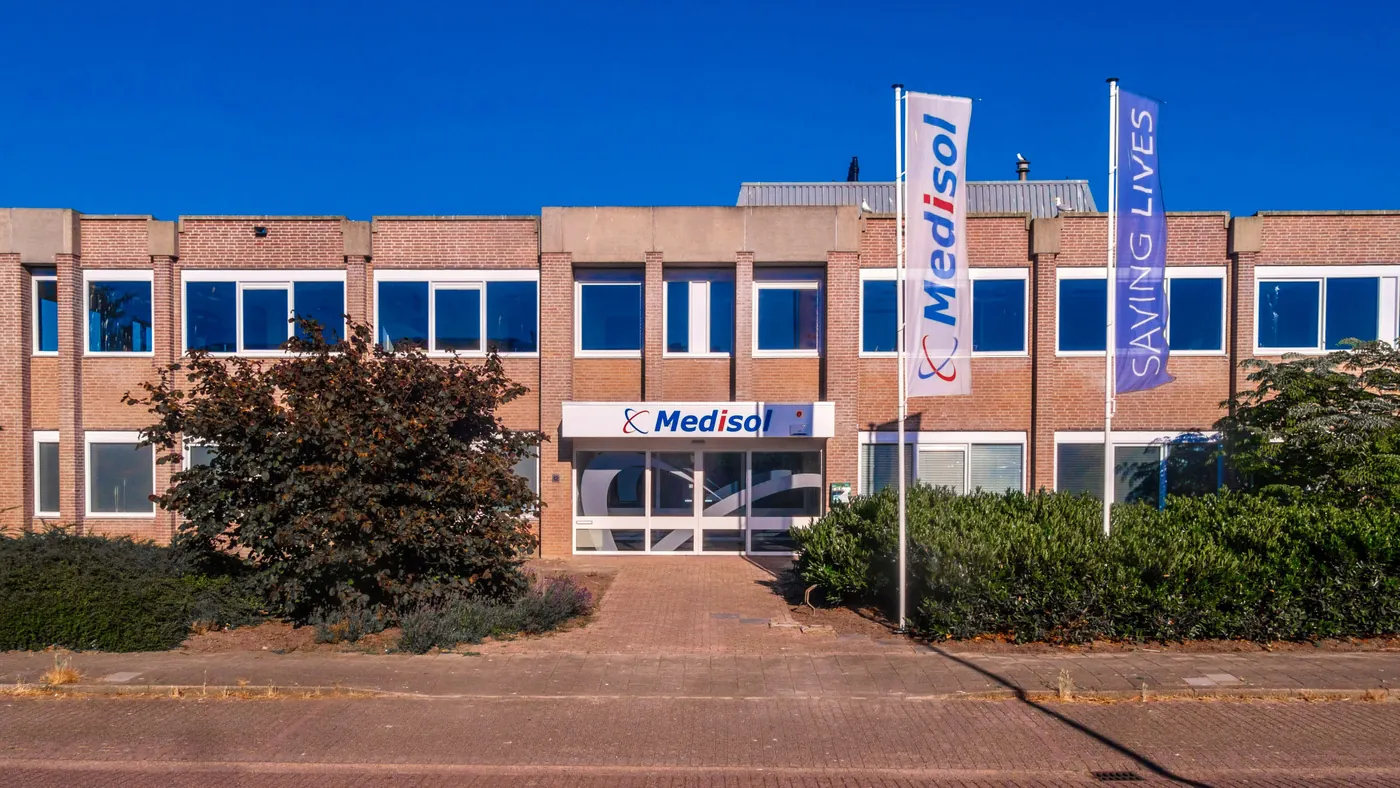 The Medisol building with flags in front of the entrance.