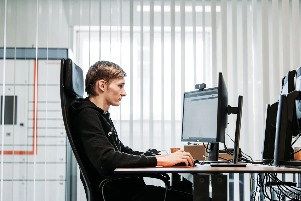 Een collega van Infodatek Group aan zijn bureau, klaar om de telefoon op te pakken.