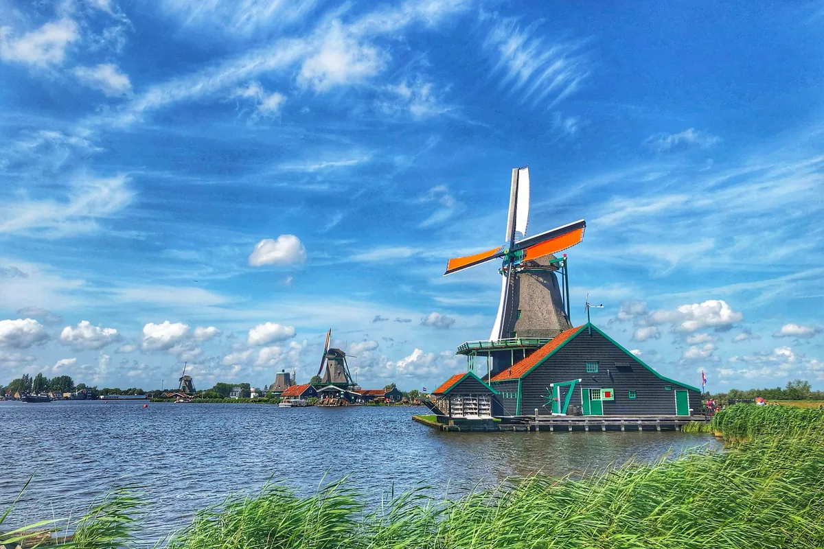 A windmill by the water in a Dutch polder.