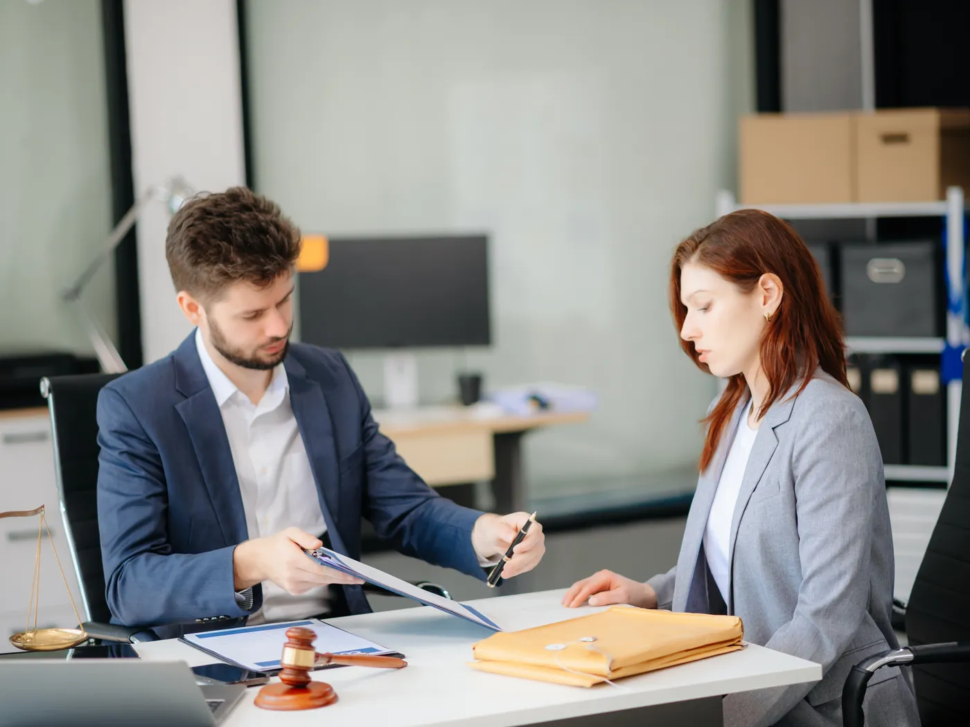 An adviser goes through a document with a client at his desk.