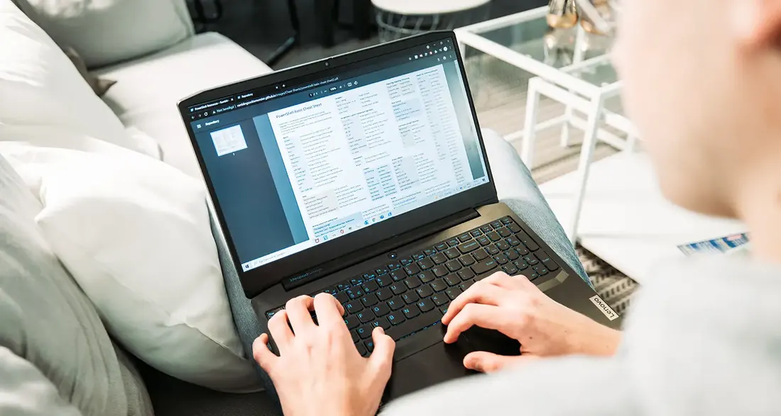 Someone working on a laptop from the sofa.